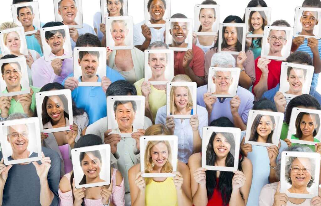 people holding pictures of faces reflecting their individuality and the importance of personalized experience for hotel guests