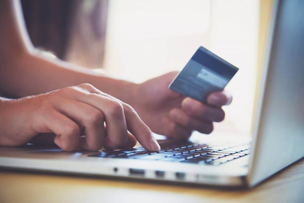 person using a laptop to pay for a hotel online booking using a credit card 