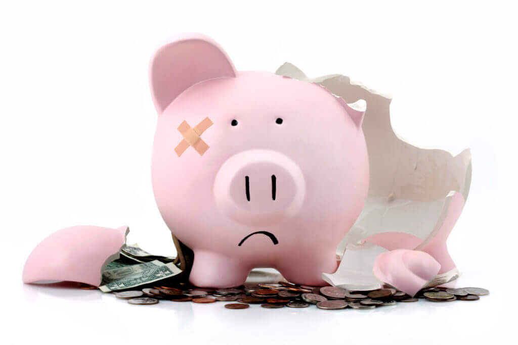 broken piggy bank with money at feet showing revenue challenges in financial crisis