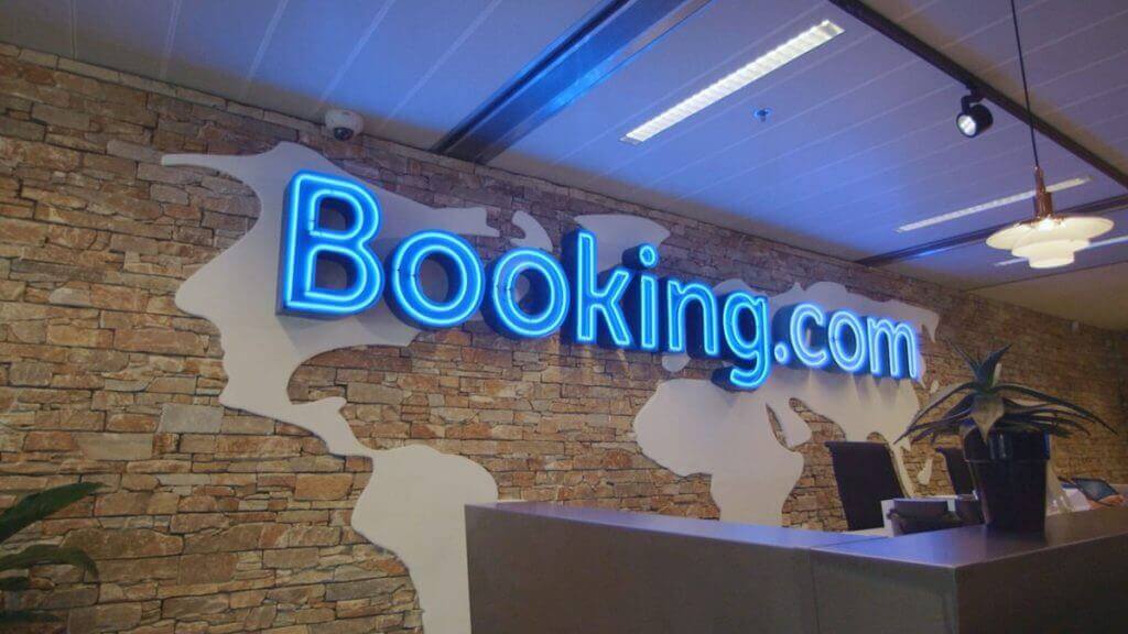 booking.com office with logo above desk as they launch new genius loyalty program