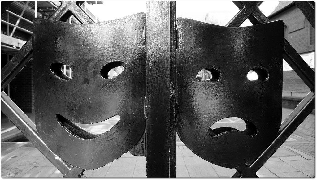 gate with two metal faces one smiling and one frowning reflecting some bad actors in the otas space