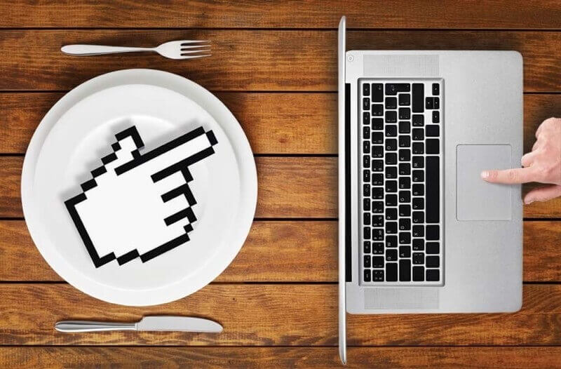 picture of finger clicking on laptop near a plate reflecting how the hotel sector have adapted their F&B offerings