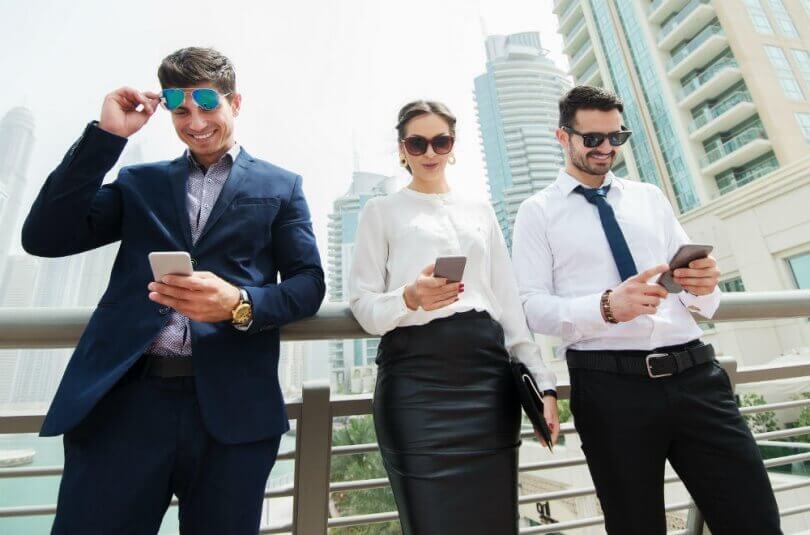 3 people looking at their phones reading an email, text or some form of marketing