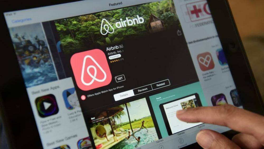 airbnb app logo being downloaded onto a tablet device