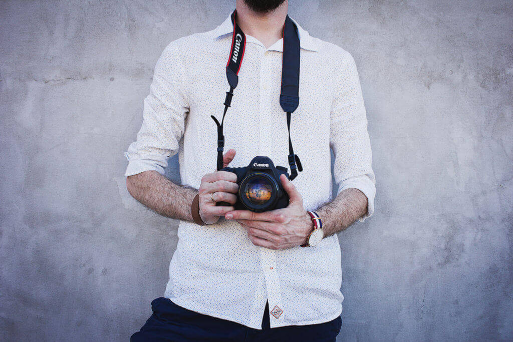 man holding camera taking photos to help upselling with quality hotel photo image