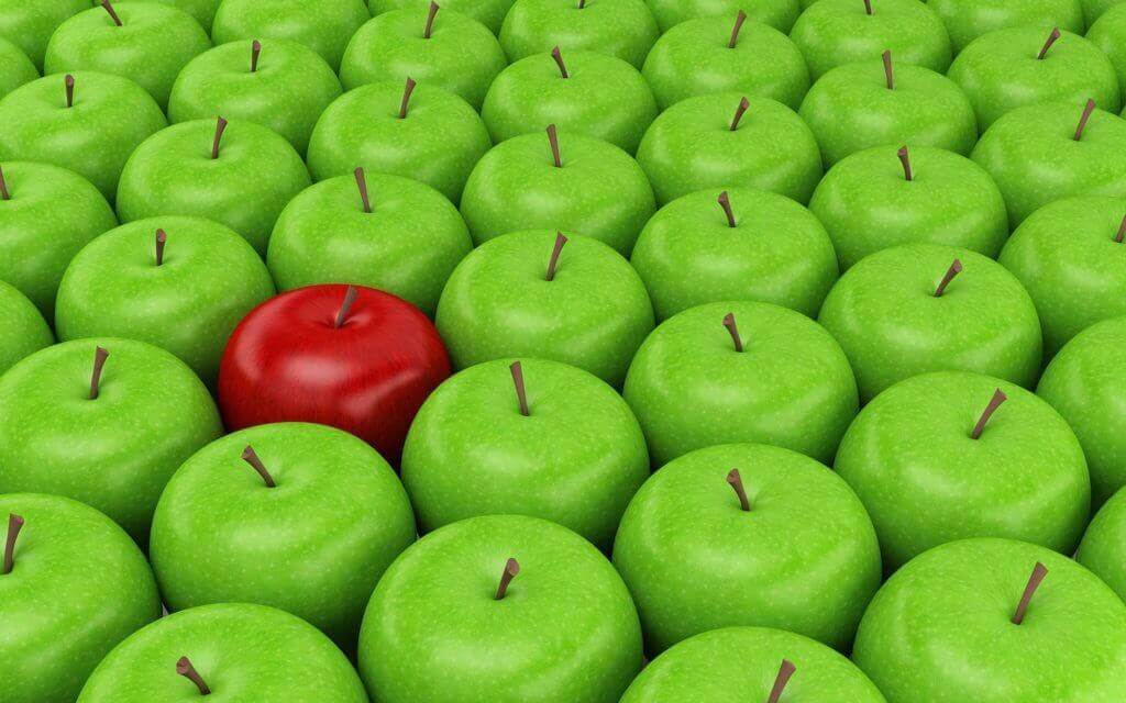 one red apple in amongst green apples