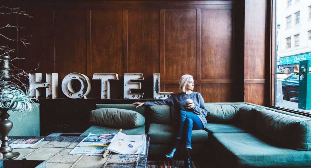 person sitting in a hotel as hoteliers review trends for 2022