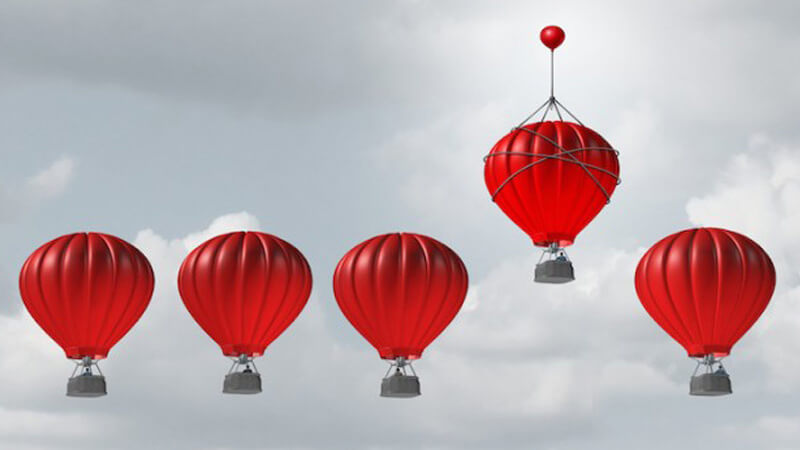 one hot air balloon rising above 4 others reflecting importance of benchmarking for hotels to adjust their strategies