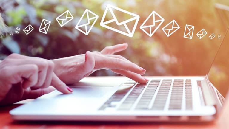 fingers on a keyboard with envelopes flying in air reflecting importance of email within hotels marketing and communication strategy