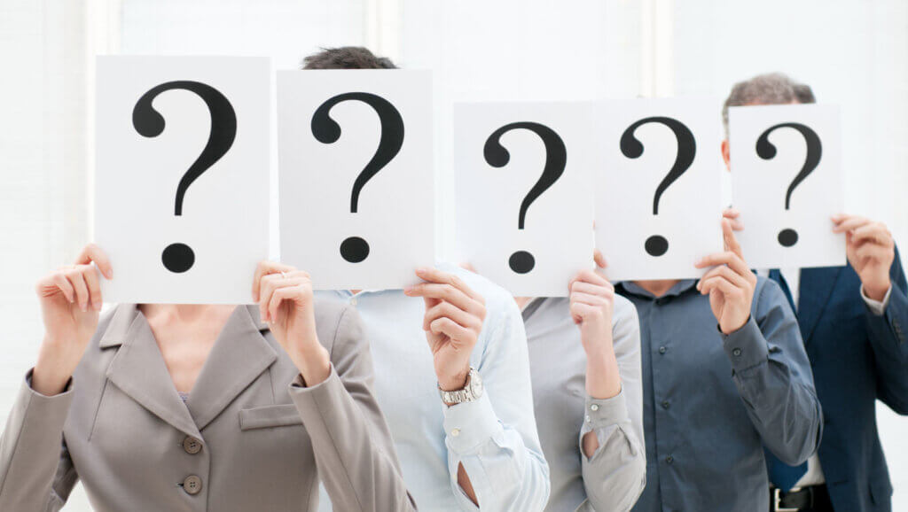 5 people holding question marks reflecting the important of faqs in your hotel seo strategy