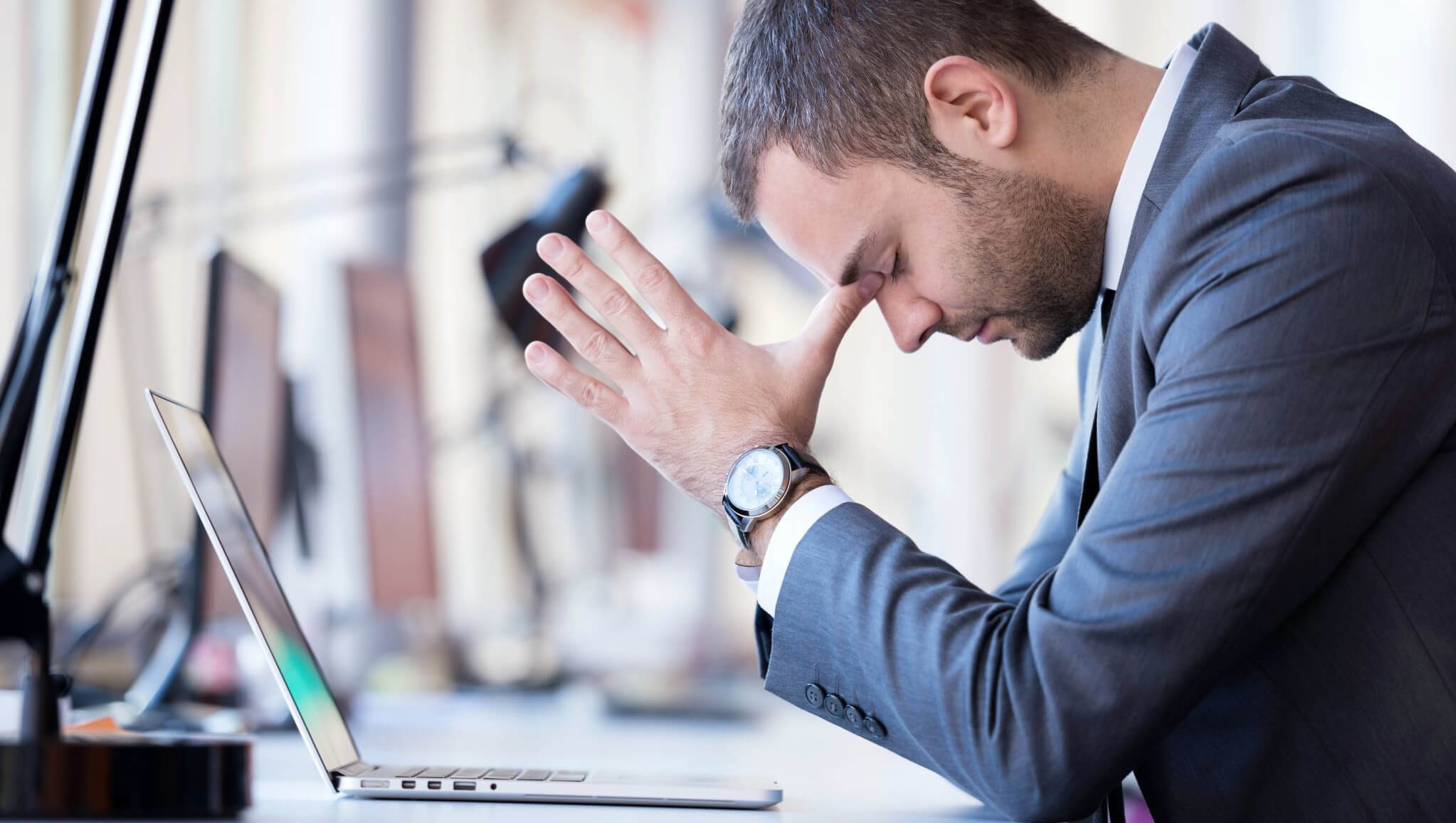 man looking in despair possibly after trying to book on a hotel website and finding it frustrating because of common mistakes