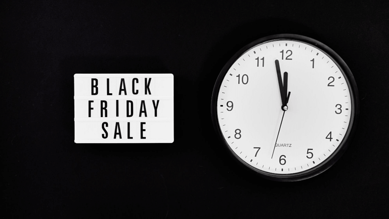clock with a poster highlighting a black friday sale hotels are running on their website