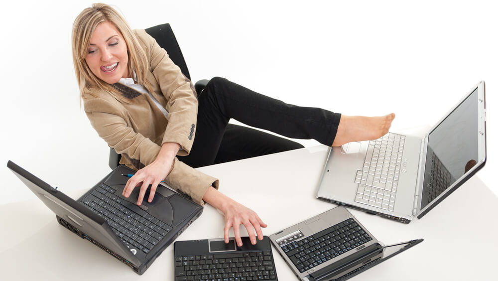 person with multiple laptops reflecting importance to a hotel of revenue management automation to ensure managers can focus on strategic issues and what is most important