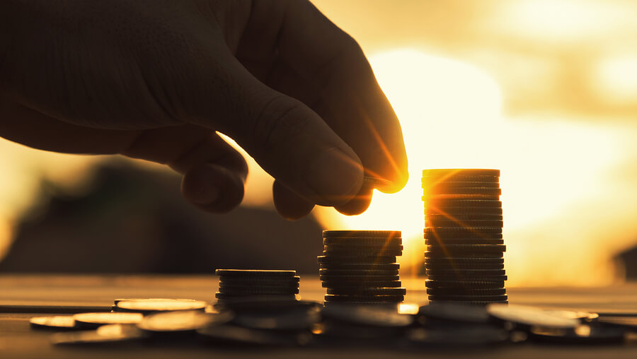 person stacking a pile of coins much like hotels need winning tactics on their website to supercharge their summer bookings