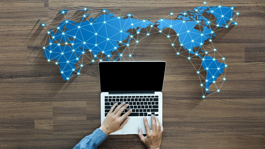 world map with connected dots and man on laptop reflecting hotel wholesale distribution strategy