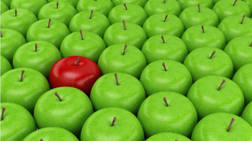 one red apple amongst many green apples reflecting need for hotels to differentiate itself from it's competitors