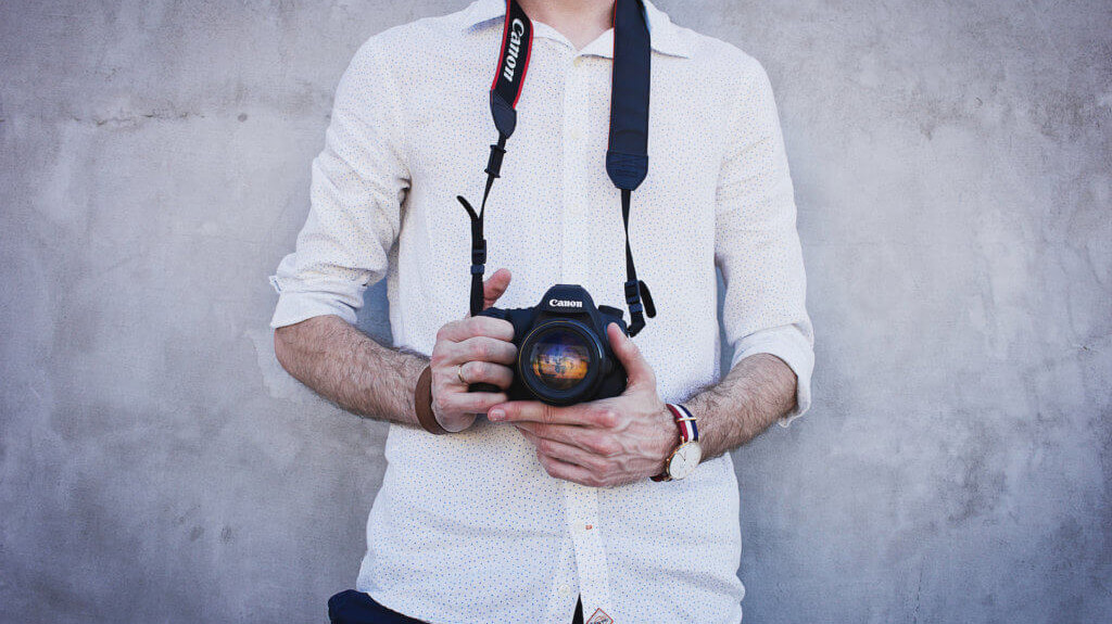 man holding a camera illustrating how importance hotel photos can be to drive conversions and bookings