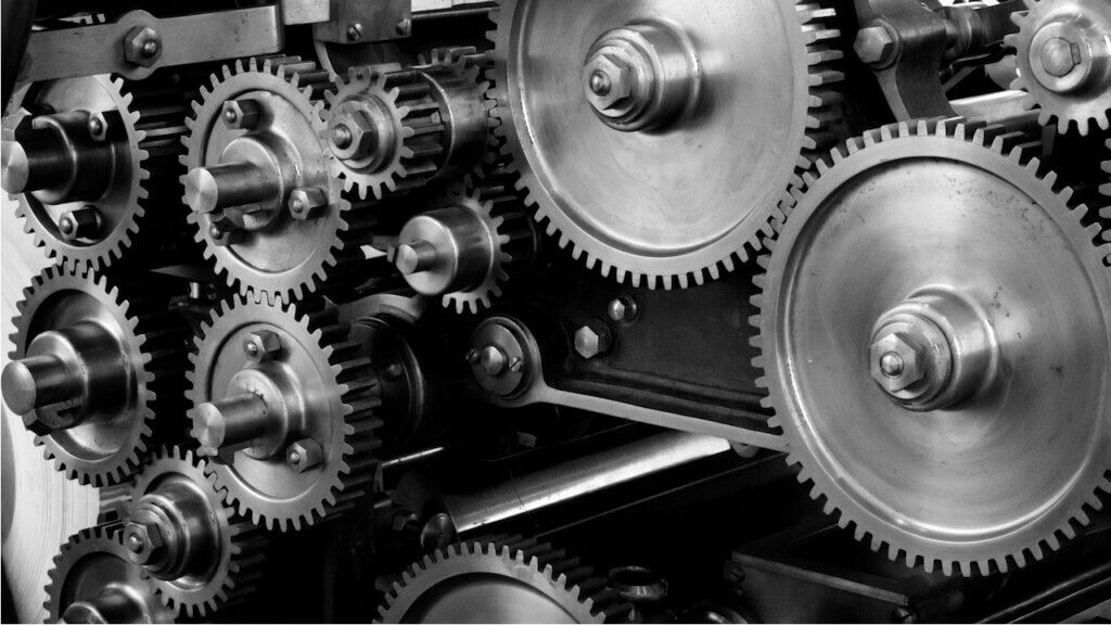 black and white picture of cogs on a machine reflecting the often outdated tech stack and signs your hotel might be in that position