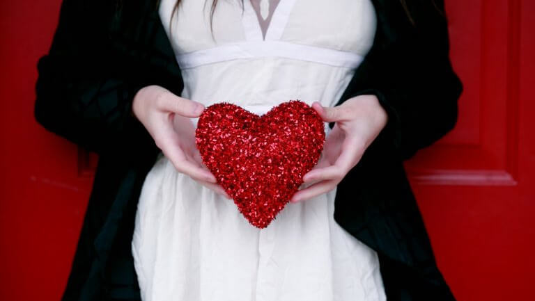 person holding a heart reflecting importance of valentines day to hotels and the need to develop strategies to attract direct bookings