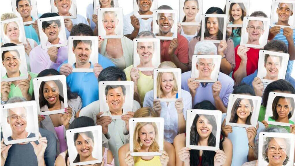 people holding up faces reflecting different personas and importance for hotels to adopt a crm to level up their marketing efforts