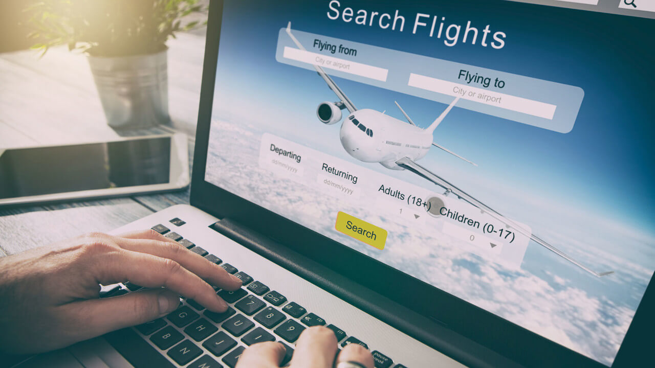 person searching for flights on a laptop reflecting the airlines shift from static to open pricing