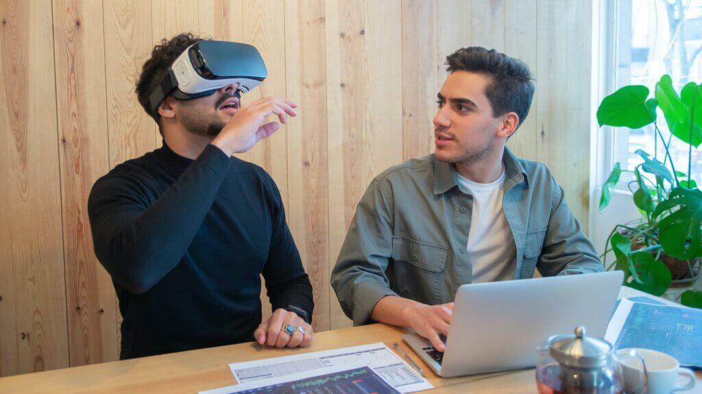 two men one with a vr headset exploring the metaverse