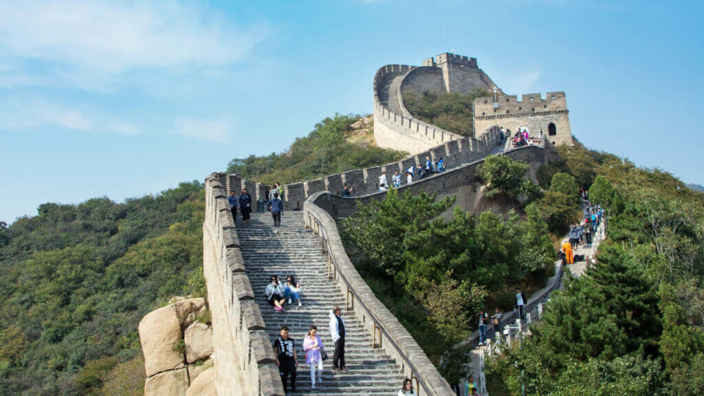 people sitting on the great wall of china reflecting travel experiences that can enhance travel through hotel distribution strategy