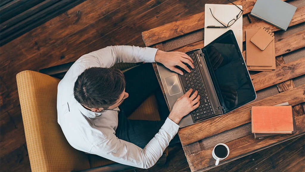 millennial on a laptop possibly booking a hotel