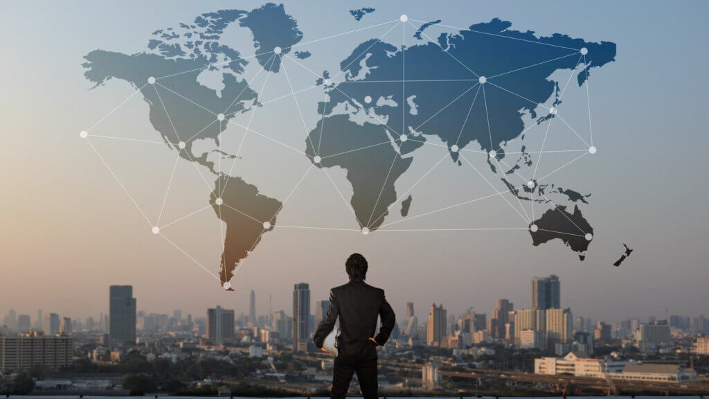 man looking at map with dots in different countries reflecting fragile global economy affecting hotel performance