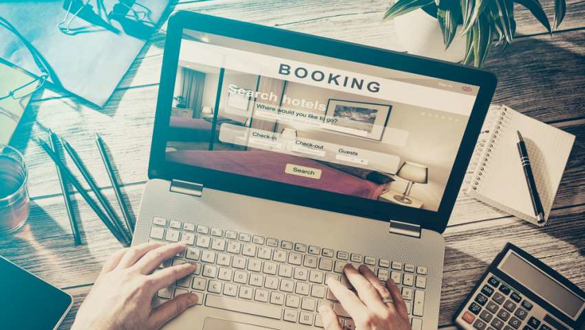 person on a laptop making a hotel booking either via and ota or direct on the hotel website