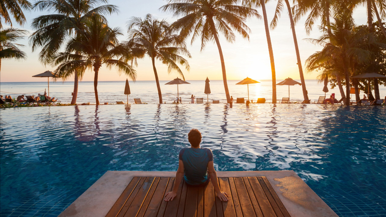 person sitting by a pool possibly taking advantage of a high season game changing offer which can drive more hotel revenue