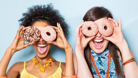 two people looking through donuts and appearing happy reflecting the impact of how hotel online reviews can shape a happy guest experience
