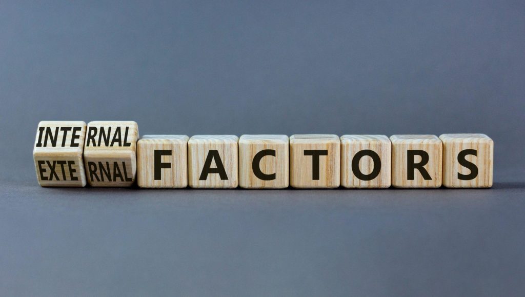 wooden blocks with letters spelling out internal and external factors reflecting elements for hotels to consider when looking at demand forecasting and market intelligence in revenue management