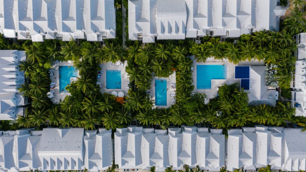 hotel and swimming pools surrounded by palm tress reflecting importance of hotel sustainability on the environment