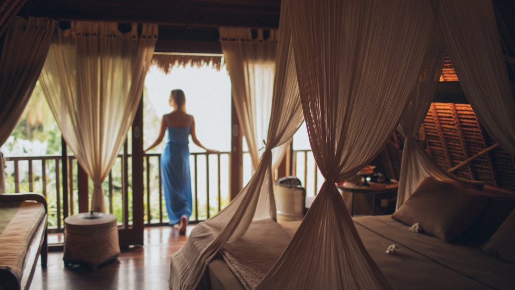 hotel guest in room with large bed reflecting growing importance of sleep tourism to hotels