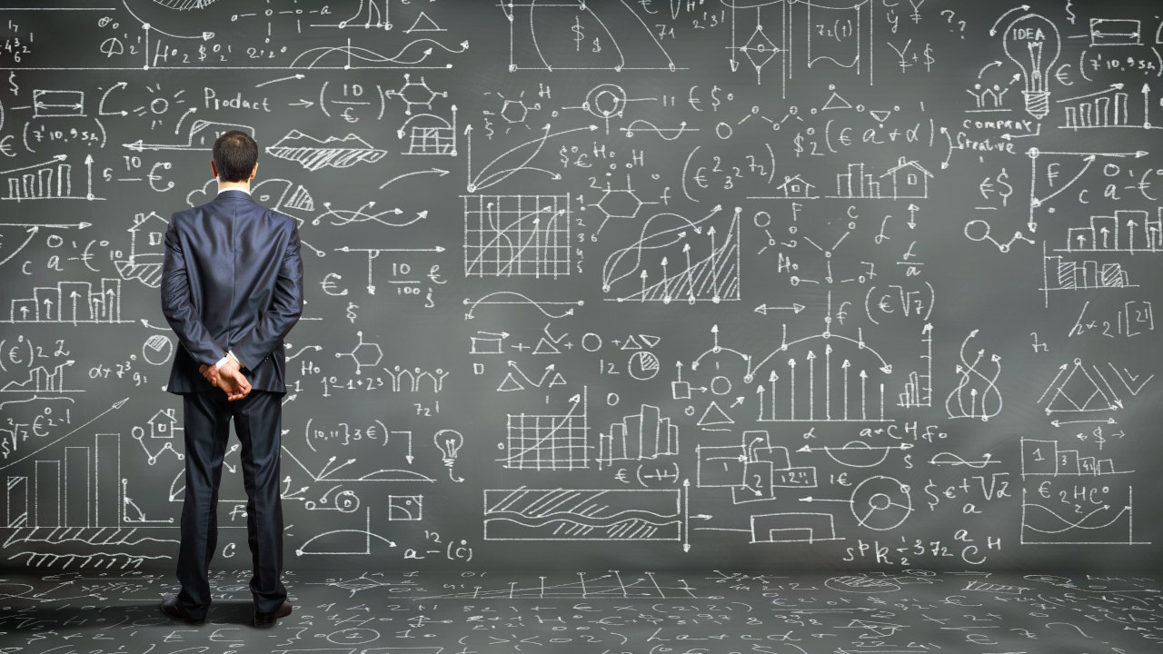 man standing in front of calculations and algorithms reflecting the multi levels of hotel revenue and how important it is that the revenue manager and general manager work in synch