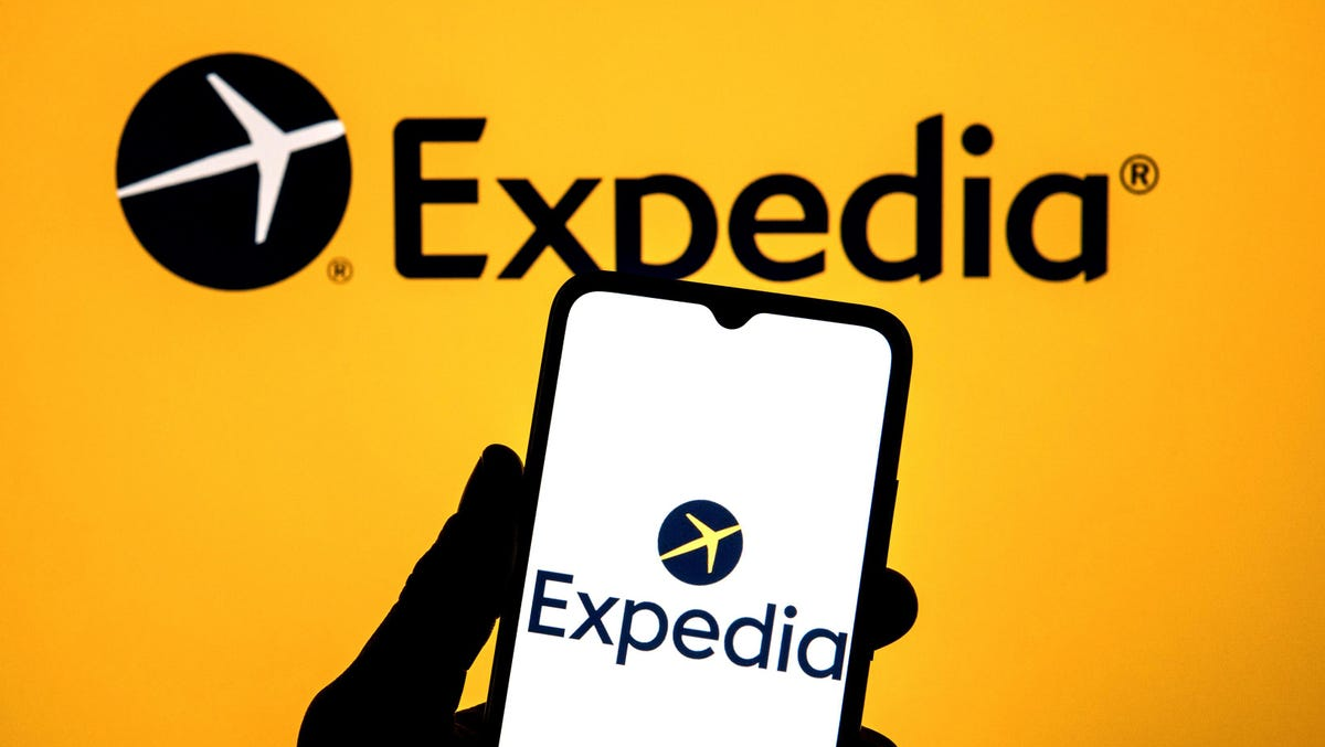 expedia logo in background and on mobile phone is a key distribution channel for hotels