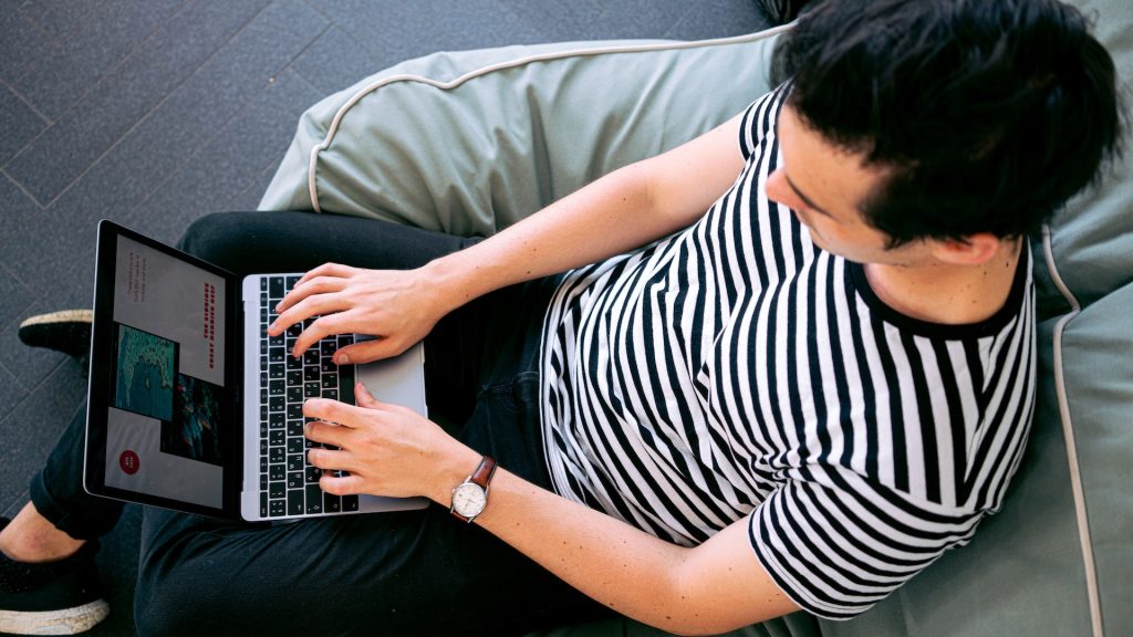 man on laptop visiting website maybe signing up to a hotel newsletter for or travel bookings