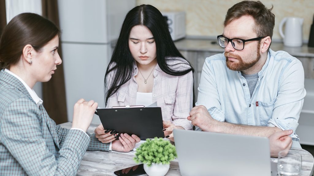 three people looking at a proposal possibly hotel group sales person with some meeting planners