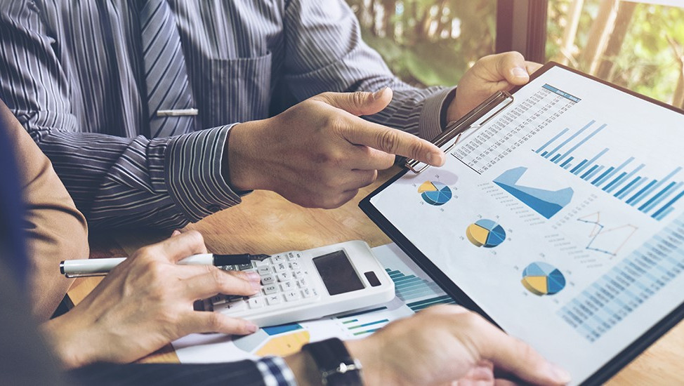 people looking at a dashboard on a tablet possibly a revenue management meeting reviewing current performance