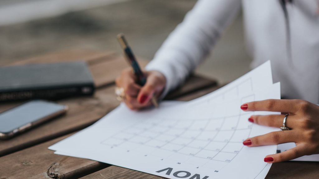 person writing on a diary asking the question if your marketing calendar misses the travel planning window