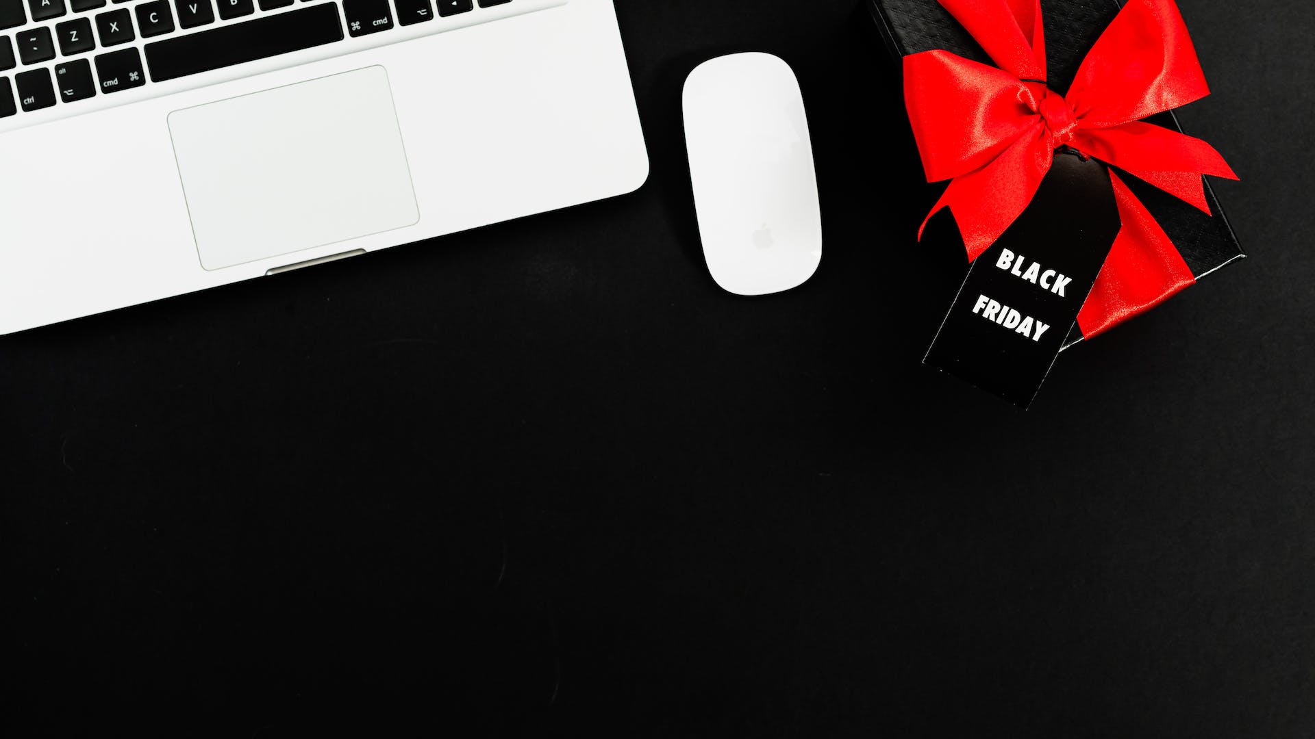 gift with black friday tag next to a laptop and mouse reflecting importance of black friday to hoteliers and the need to identify best practices for success