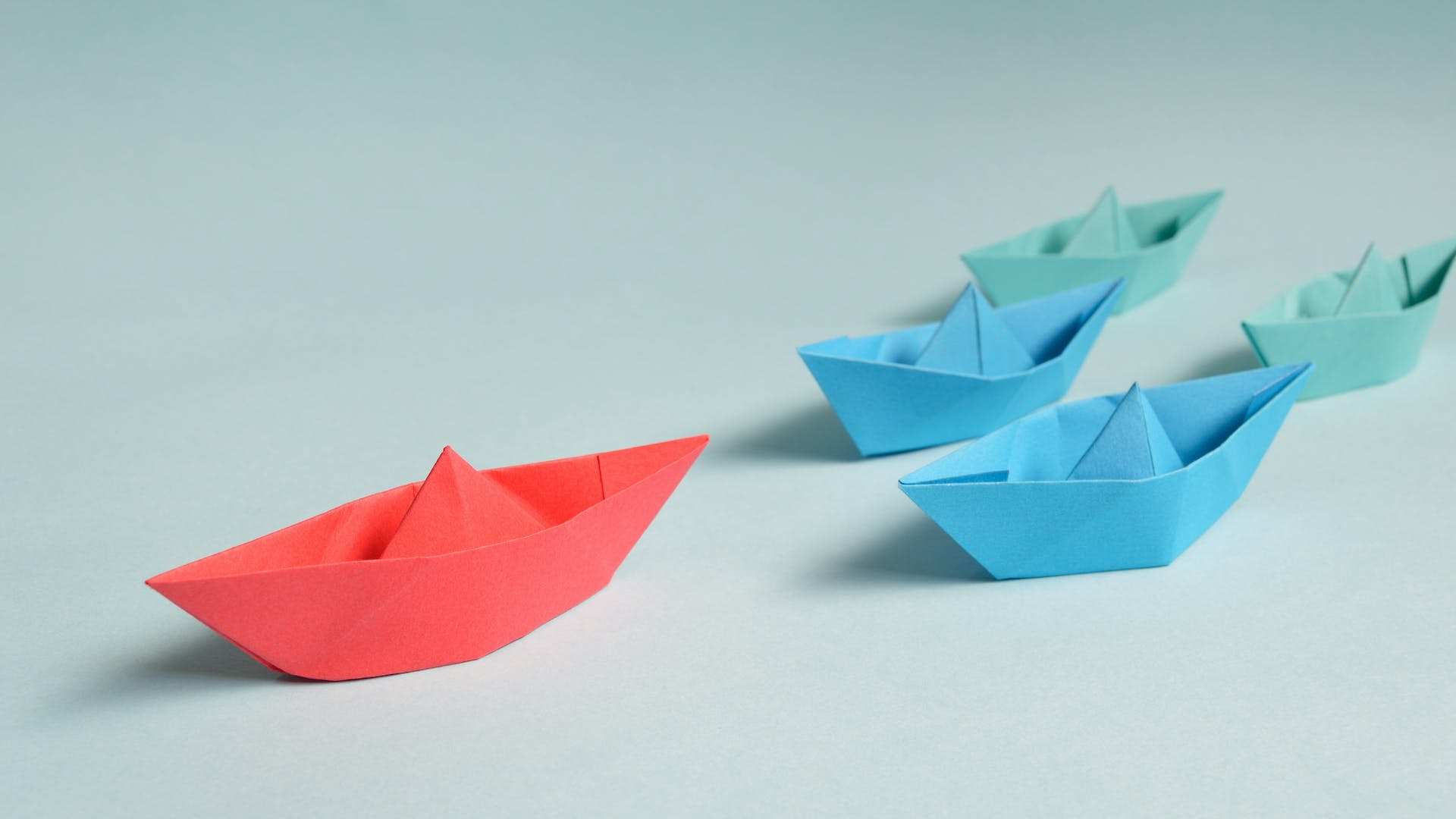 5 paper boats of different colours with one in front reflecting the need for hoteliers to go beyond rates with creative revenue management strategies
