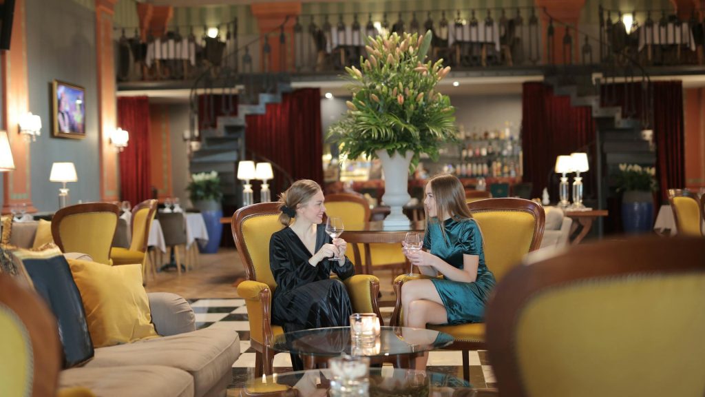 2 hotel guests enjoying a drink in the bar maybe encouraged by an upselling strategy