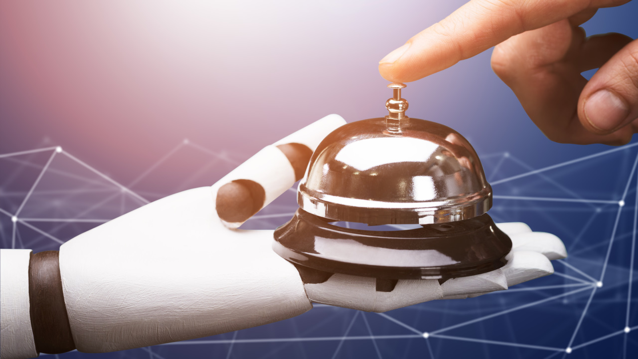 hotel reception bell being held by a robot reflecting the impact ai and technology will have on the future hotel experience