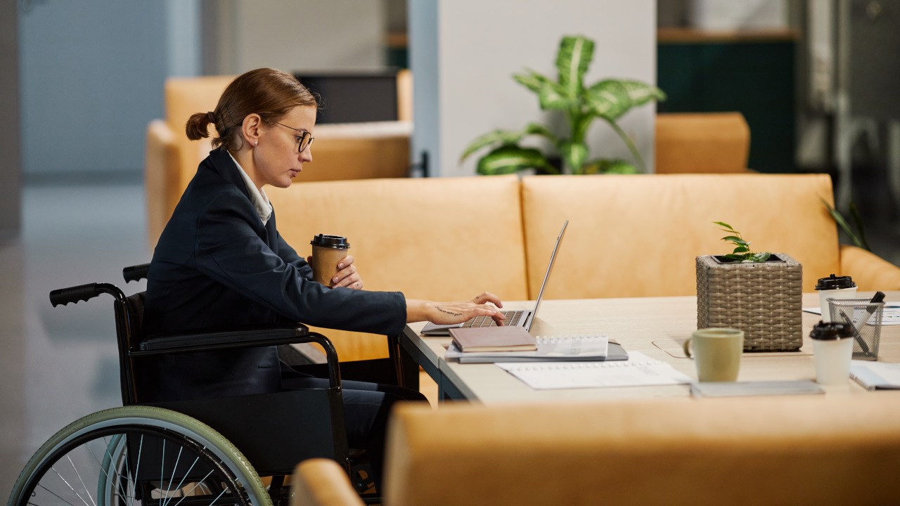 lady in a wheelchair looking at a laptop possibly an ada complaint hotel website