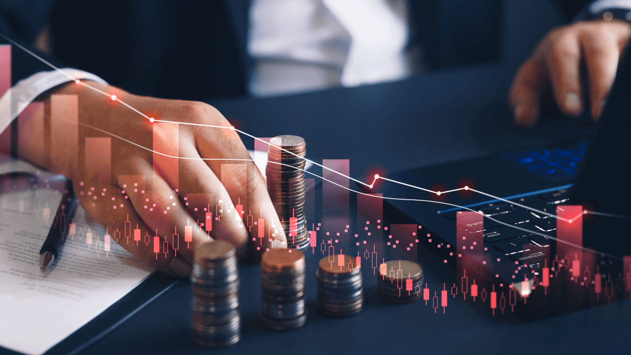 a person at a laptop with coins and a graph overlay illustrating the questions of rms technology over human revenue manager