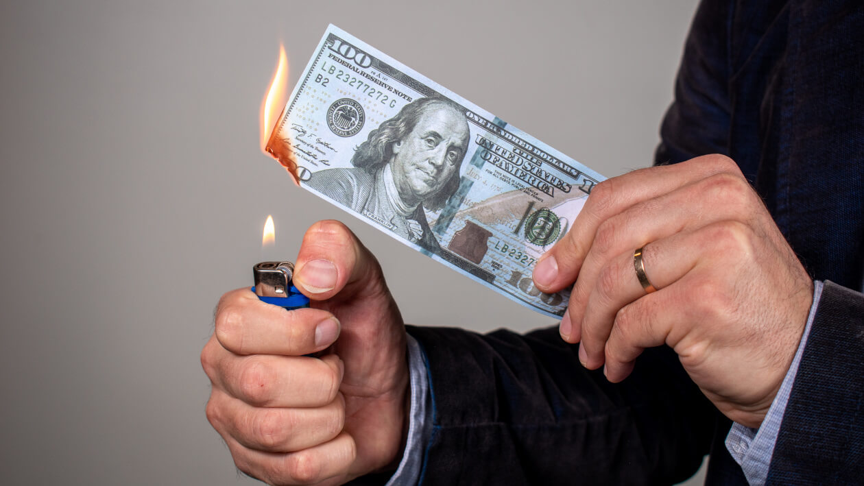 man burning money in much the same way hotels waste ad budget by not choosing the best markets and platforms