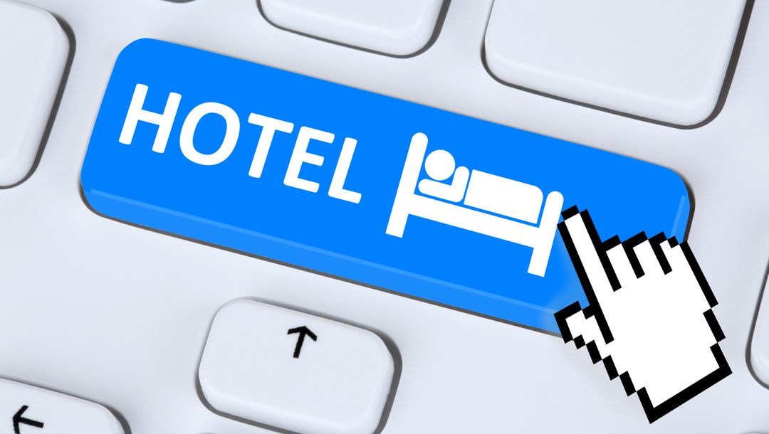 pixelated finger clicking on a button saying hotel reflecting the importance of winning strategies to increase direct bookings and checkmate otas