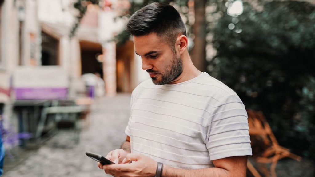 man on mobile phone reflecting the importance of guest communication and pre-arrival mistakes hotel should avoid